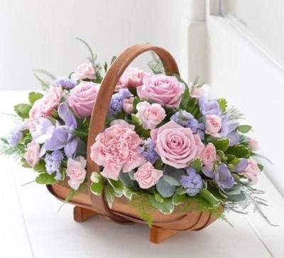 Cane basket arrangement - Basket of fresh flowers in a basket in shades of pinks and lilacs