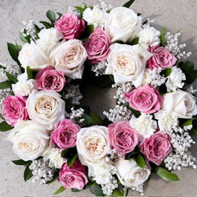 Blossom Serenity Wreath - A beautifully crafted floral wreath featuring a harmonious blend of soft pink and creamy white roses, accented with delicate baby's breath and lush green foliage.