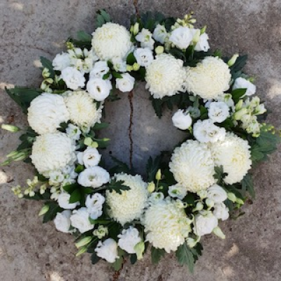Pure Remembrance Wreath - A serene and graceful floral wreath composed entirely of white blooms, featuring full, soft chrysanthemums, delicate lisianthus, and buds nestled among rich green foliage.